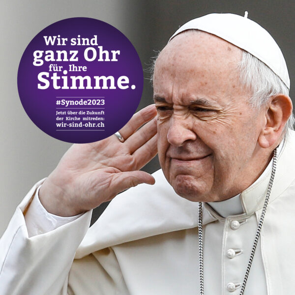 Papst Franziskus hält die Hand ans Ohr.